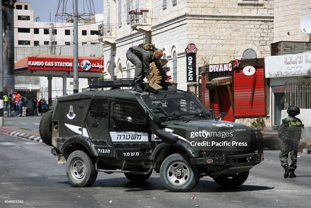 Israeli soldiers prepare the vehicle to fire tear gas at the...