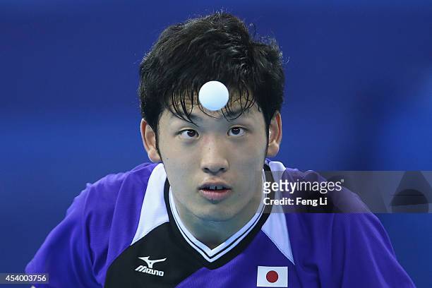 Yuto Muramatsu of Japan competes Fan Zhendong of China in table tennis Mixed International Team Gold Medal match during day seven of the Nanjing 2014...
