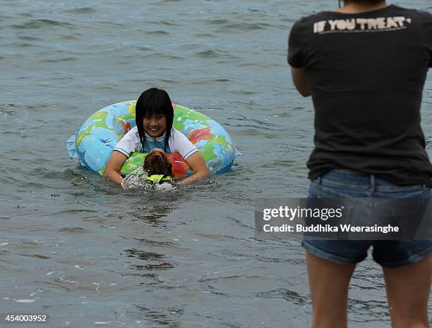 Pet dog wear life jacket and take a bath in the sea with his owner at Takeno Beach on August 23, 2014 in Toyooka, Japan. This beach is open for dogs...