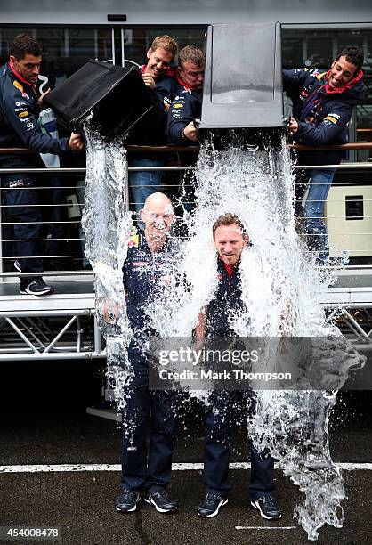 Sebastian Vettel of Germany and Infiniti Red Bull Racing and Daniel Ricciardo of Australia and Infiniti Red Bull Racing pour buckets of ice water...