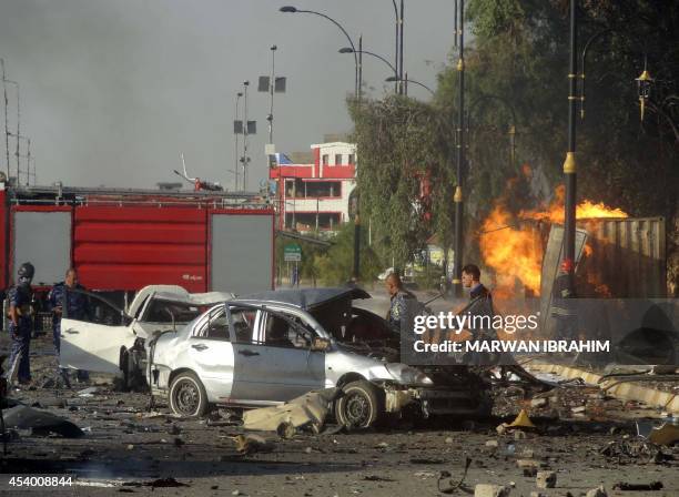 Iraqi emergency service personnel inspect the sit of a roadside bomb attack near under-construction buildings in the Kurdish-controlled northern...