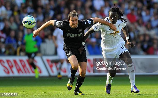 Burnley player Michael Duff challenges Swansea forward Bafetimbi Gomis during the Barclays Premier League match between Swansea City and Burnley at...