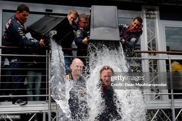 Sebastian Vettel of Germany and Infiniti Red Bull Racing and Daniel Ricciardo of Australia and Infiniti Red Bull Racing pour buckets of ice water...