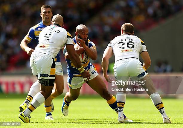 Jamie Jones-Buchanan of Leeds is tackled by Jake Webster and Liam Finn of Castleford during the Tetley's Challenge Cup Final between Leeds Rhinos and...