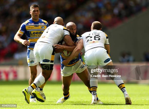 Jamie Jones-Buchanan of Leeds is tackled by Jake Webster and Liam Finn of Castleford during the Tetley's Challenge Cup Final between Leeds Rhinos and...