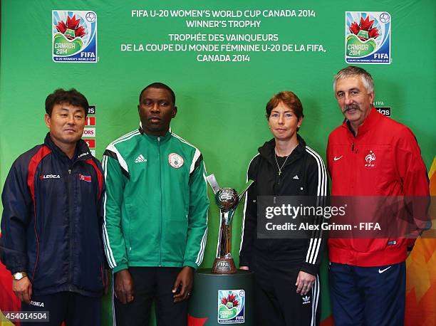 Head coaches Hwang Yong Bong of Korea DPR, Peter Dedevbo of Nigeria, Maren Meinert of Germany and Gilles Eyquem of France pose with the trophy during...