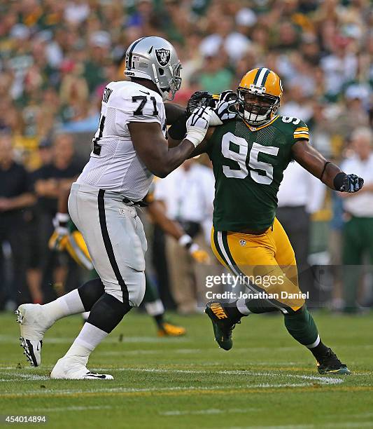 Datone Jones of the Green Bay Packers rushes against Menelik Watson of the Oakland Raiders during a preseason game at Lambeau Field on August 22,...