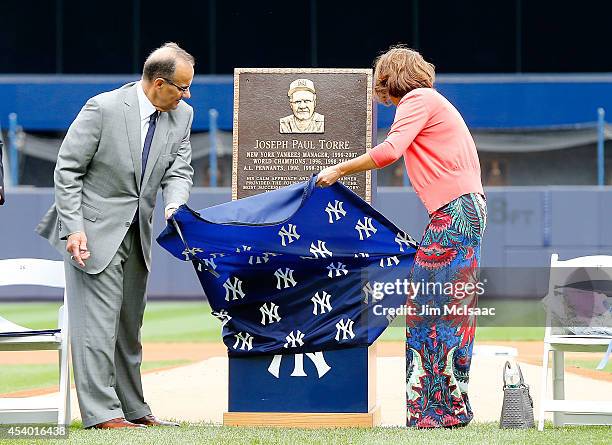 Former New York Yankees manager Joe Torre unviels his plaque that will be installed in Monument Park with his wife Ali at Yankee Stadium during a...