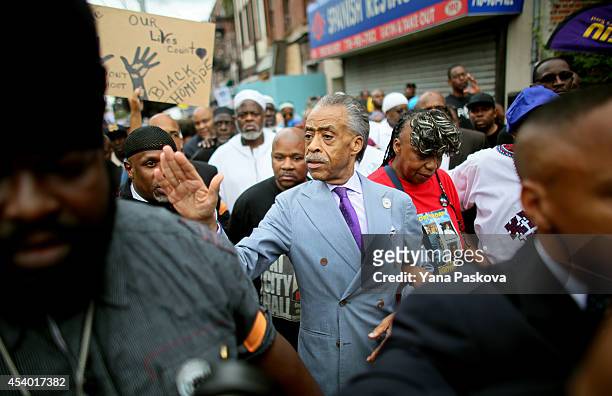 Reverend Al Sharpton and Gwen Carr, mother of police violence victim Eric Garner, march during a rally against police violence on August 23, 2014 in...