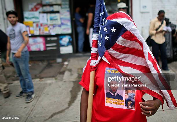 Evelina Graham drapes herself in the American flag during a rally against police violence on August 23, 2014 in the Staten Island borough of New York...