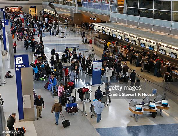 Passengers waiting to speak with ticket agents at American Airlines line the length of Terminal D at DFW International Airport December 6, 2013 in...