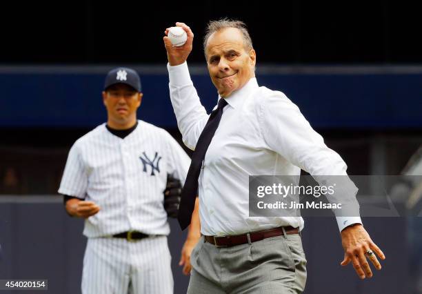 Former New York Yankee manager Joe Torre throws out the ceremonial first pitch before a game against the Chicago White Sox as Hiroki Kuroda looks on...