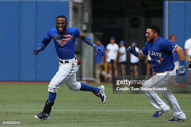 Jose Reyes of the Toronto Blue Jays is congratulated by Melky Cabrera in the 10th inning after hitting the game-winning single during MLB game action...