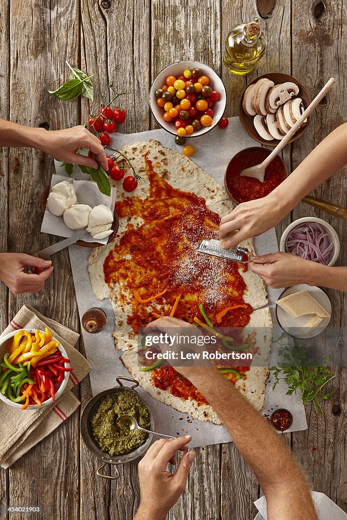 People making a flatbread pizza
