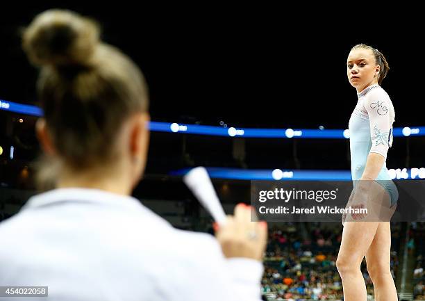 Jazmyn Foberg talks with her coach, Maggie Haney, before competing on the floor exercise in the junior women finals during the 2014 P&G Gymnastics...