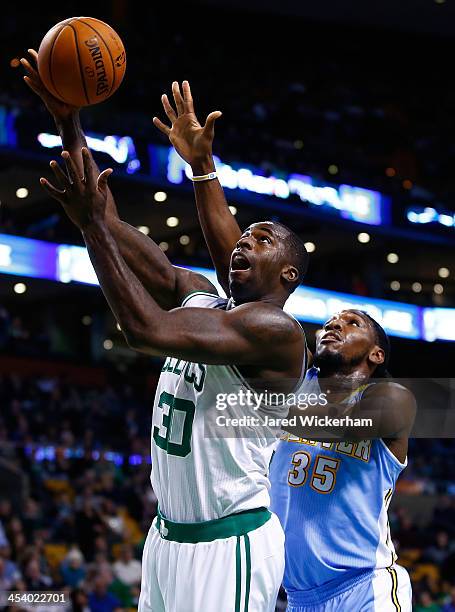 Brandon Bass of the Boston Celtics goes up for a layup in front of Kenneth Faried of the Denver Nuggets in the first quarter during the game at TD...