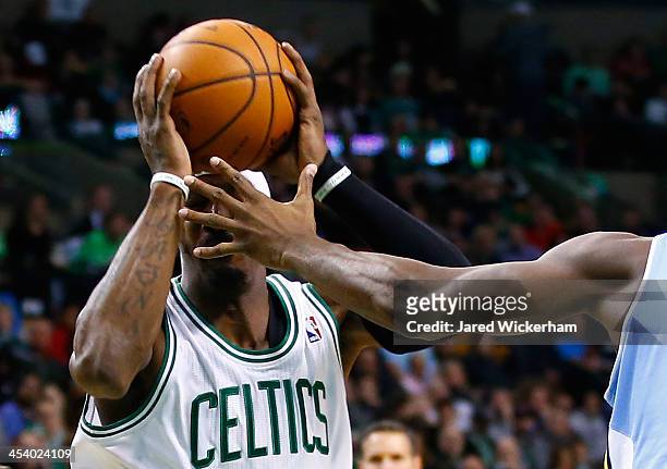 Gerald Wallace of the Boston Celtics is defended by the hand of Kenneth Faried of the Denver Nuggets in the second quarter during the game at TD...
