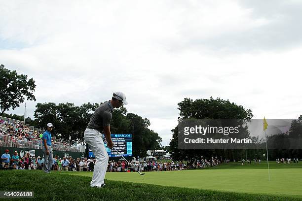 Paul Casey of England ships in for birdie on the 18th green during the third round of The Barclays at The Ridgewood Country Club on August 23, 2014...