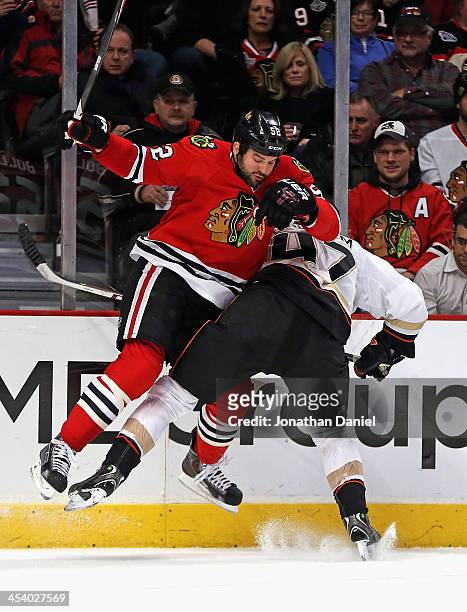Brandon Bollig of the Chicago Blackhawks collides with Hampus Lindholm of the Anaheim Ducks at the United Center on December 6, 2013 in Chicago,...