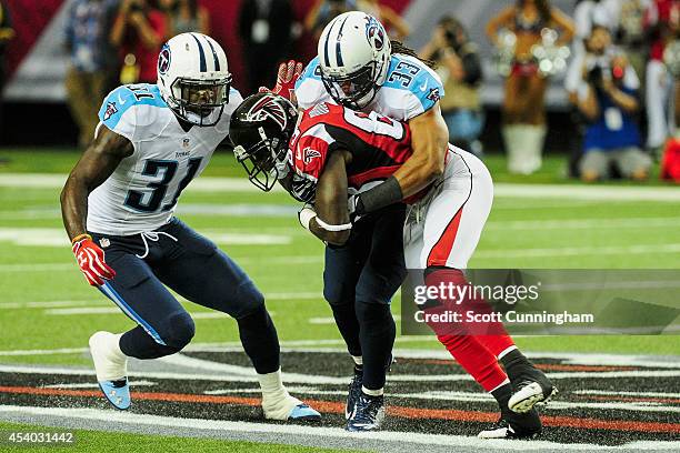 Michael Griffin and Bernard Pollard of the Tennessee Titans tackle Harry Douglas of the Atlanta Falcons after a catch in the first half of a...