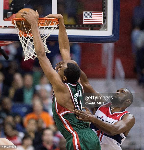 Milwaukee Bucks power forward John Henson slam dunks on Washington Wizards small forward Chris Singleton during the second half of their game played...