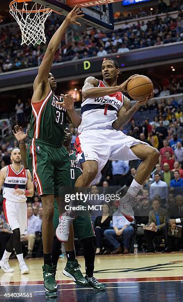 Washington Wizards small forward Trevor Ariza passes the ball while being guarded by Milwaukee Bucks power forward John Henson during the second half...