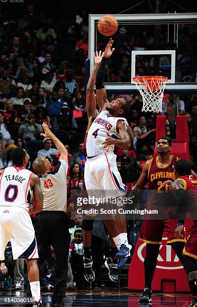 Paul Millsap of the Atlanta Hawks goes up for a rebound against the Cleveland Cavaliers on December 6, 2013 at Philips Arena in Atlanta, Georgia....