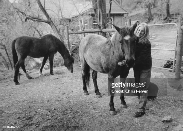Photo of Native American author and poet Linda Hogan, standing with horses, in Boulder, Colorado, 2009.