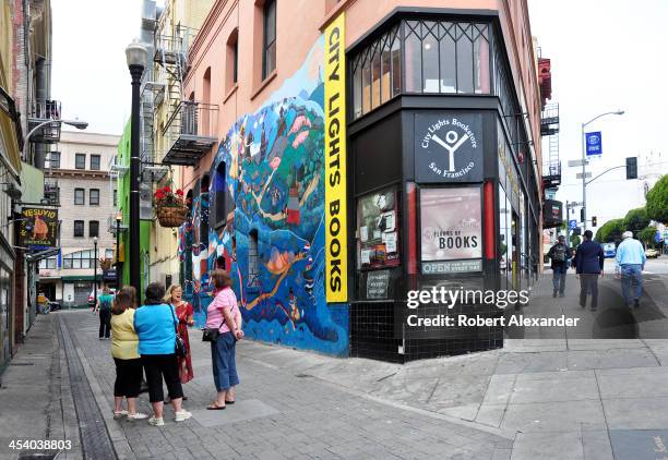 Walking tour guide talks to a small group of tourists in Jack Kerouac Alley which runs between two San Francisco landmarks, City Lights Bookstore and...