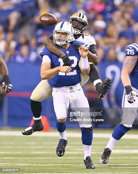 Andrew Luck of the Indianapolis Colts throws a pass as he is hit by Junior Galette of the New Orleans Saints during the exhibition game at Lucas Oil...