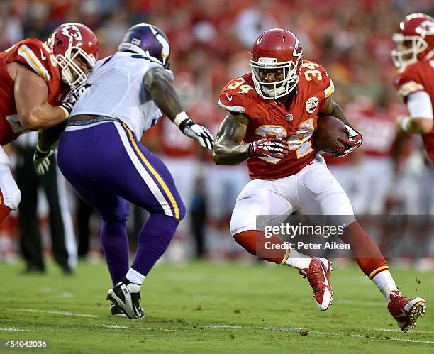 Knile Davis of the Kansas City Chiefs runs the ball as Ricky Henry of the Kansas City Chiefs controls Sharrif Floyd of the Minnesota Vikings at...