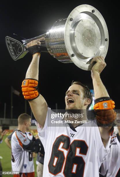 Defender Michael Simon of the Denver Outlaws holds up the Steinfeld Trophy after winning the 2014 Major League Lacrosse Championship Game against the...