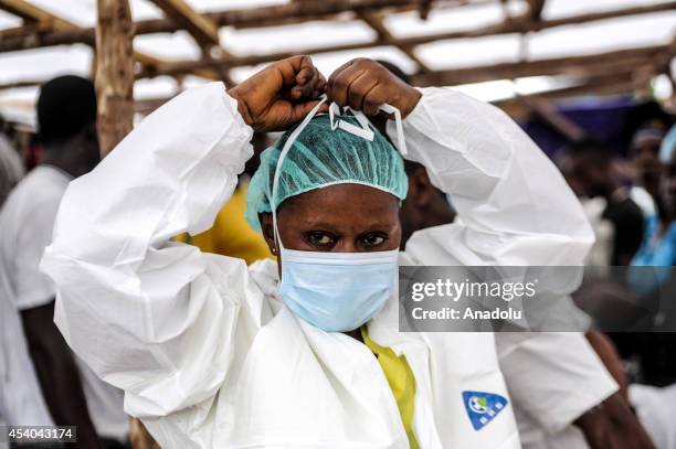 Nurse wears a special uniform to be protected from Ebola virus before delivering the food to the patients, suspected as infected with the virus, at a...