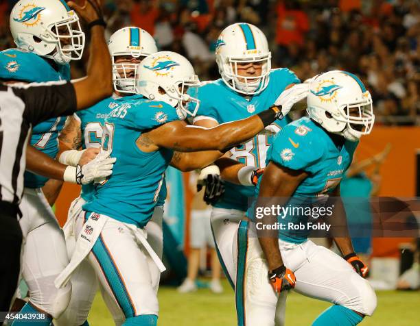 Damien Williams, right, of the Miami Dolphins celebrates with teammates after his score in the second half of play against the Dallas Cowboys during...