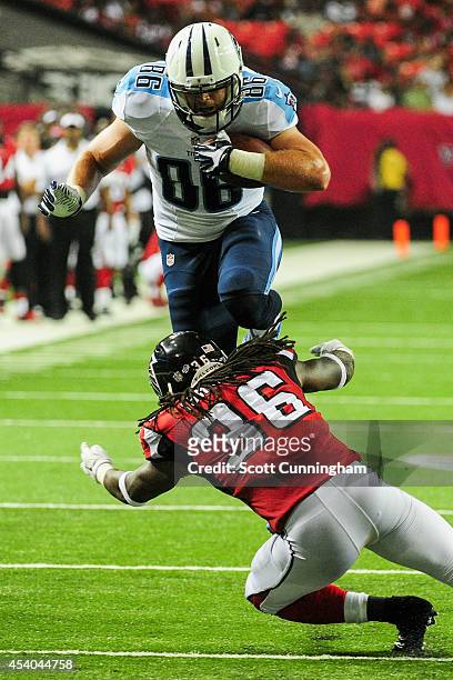 Chase Coffman of the Tennessee Titans leaps over Kemal Ishmael of the Atlanta Falcons in the second half of a preseason game at the Georgia Dome on...