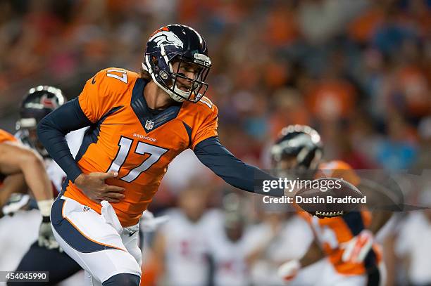 Quarterback Brock Osweiler of the Denver Broncos hands off the ball against the Houston Texans during a preseason game at Sports Authority Field at...