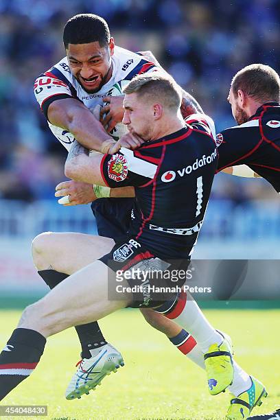 Isaac Liu of the Roosters fends off Sam Tomkins of the Warriors to score a try during the round 24 NRL match between the New Zealand Warriors and the...