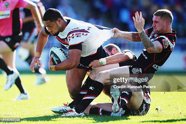 Isaac Liu of the Roosters fends off Sam Tomkins of the Warriors to score a try during the round 24 NRL match between the New Zealand Warriors and the...