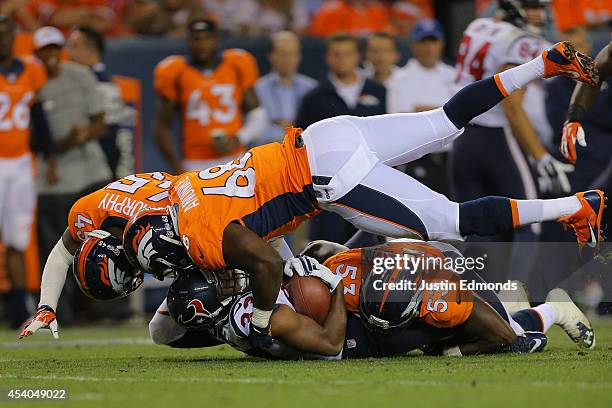 Running back William Powell of the Houston Texans is tackled behind the line of scrimmage in the fourth quarter by defensive end Kenny Anunike and...