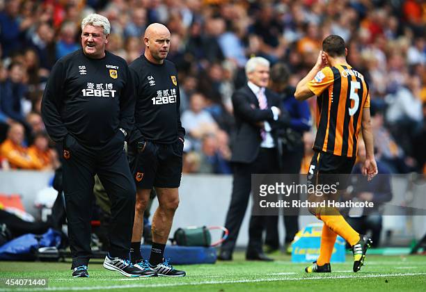 Steve Agnew assistant manager of Hull City looks on as Steve Bruce manager of Hull City reacts as James Chester of Hull City is sent off during the...