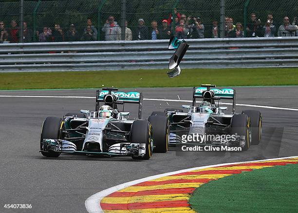 Debris flies in the air as Nico Rosberg of Germany and Mercedes GP makes contact with Lewis Hamilton of Great Britain and Mercedes GP during the...