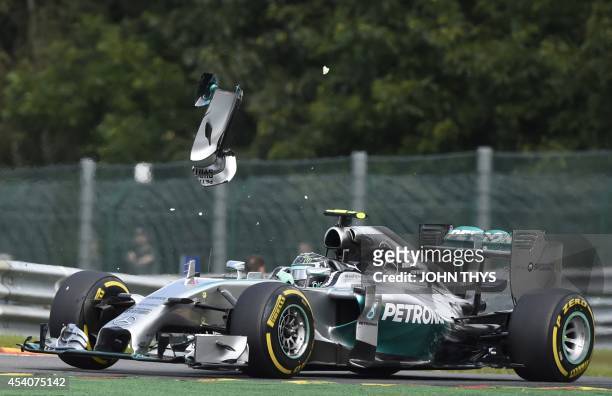 Pice of wing flys over Mercedes-AMG's German driver Nico Rosberg after a collision with teammate Mercedes-AMG's British driver Lewis Hamilton at the...