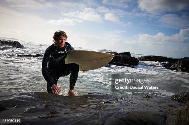 surfer getting out of the water. - wetsuit stock pictures, royalty-free photos & images