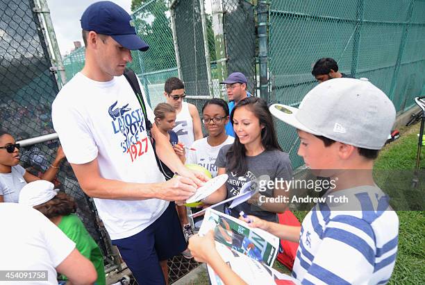 Tennis player John Isner signs autographs for fans during the City Parks Foundation's tennis clinic at the Central Park Tennis Center on August 24,...
