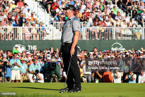 Fans applaud as Hunter Mahan celebrates on the 18th hole green after making his putt and securing victory in the final round of The Barclays at...