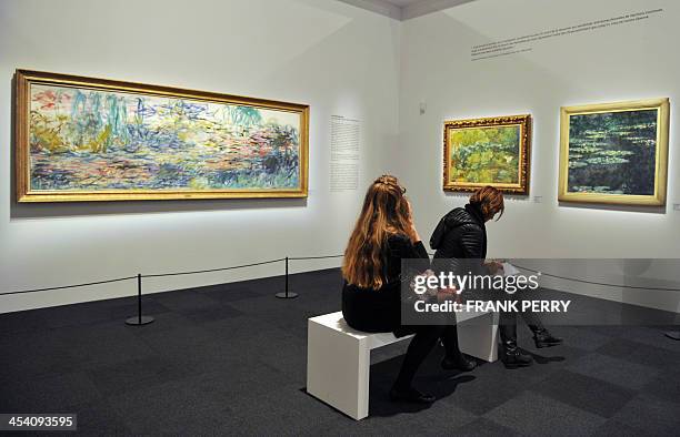 People look at paintings by French painter Claude Monet displayed in the exhibition "Clemenceau et les artistes modernes" in the Historial de le...