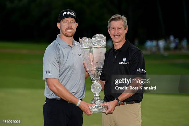 Tom King , Barclays Chief Exectutive, Investment Bank, presents Hunter Mahan with the tournament trophy after he won The Barclays at The Ridgewood...