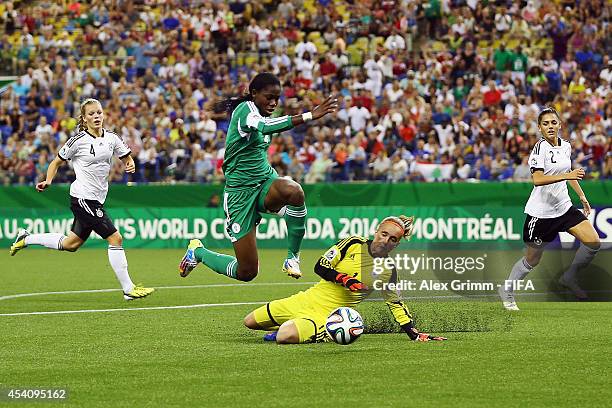 Asisat Oshoala of Nigeria is challenged by goalkeeper Meike Kaemper of Germany during the FIFA U-20 Women's World Cup Canada 2014 final match between...