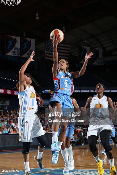 Jasmine Thomas of the Atlanta Dream drives to the basket against Courtney Clements and Sylvia Fowles of the Chicago Sky in Game Two of the Eastern...