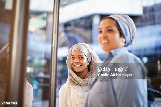 muslims friends looking at a dress through the window. - cape town bo kaap stock pictures, royalty-free photos & images